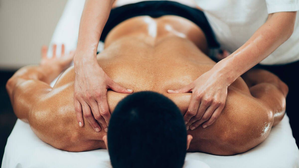 Hot Stone Massage at spa to relax muscle knots, release tension, and prepare the body for more comfortable Deep Tissue therapy.